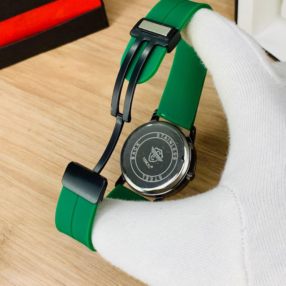 Watch with green strap on a wooden surface