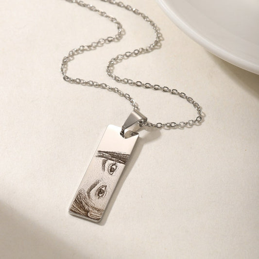 Silver necklace with a pendant on a light surface