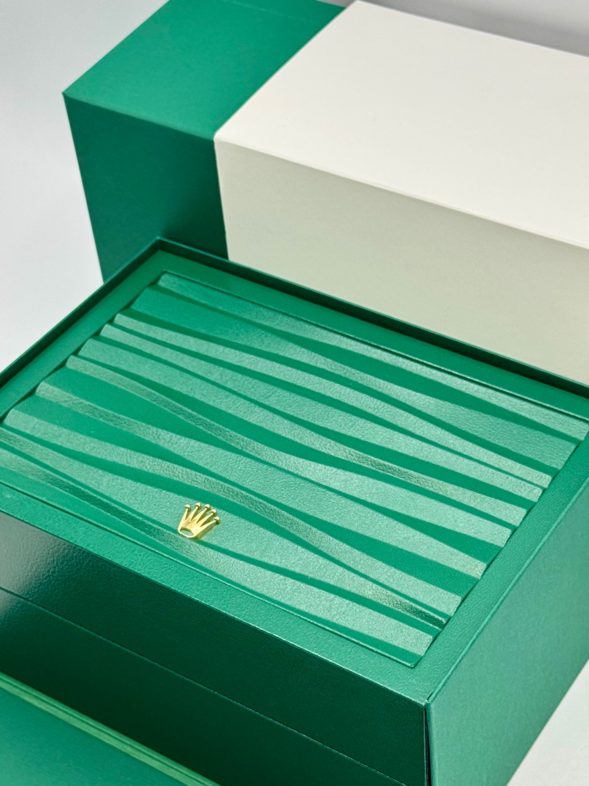 Green jewelry box with a gold emblem on a white background